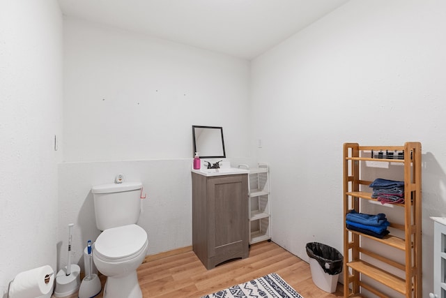 bathroom with wood-type flooring, vanity, and toilet