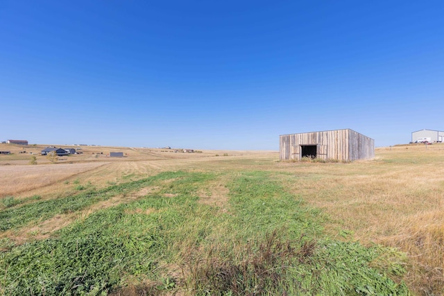 view of yard with a rural view and an outbuilding