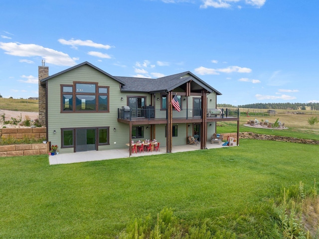 back of house featuring a rural view, a patio, and a yard