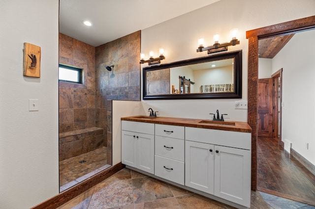 bathroom with vanity, a tile shower, and hardwood / wood-style flooring