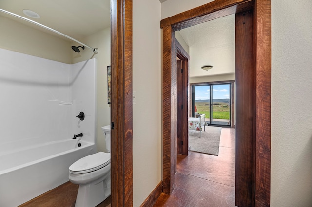 bathroom featuring tub / shower combination, tile patterned floors, and toilet