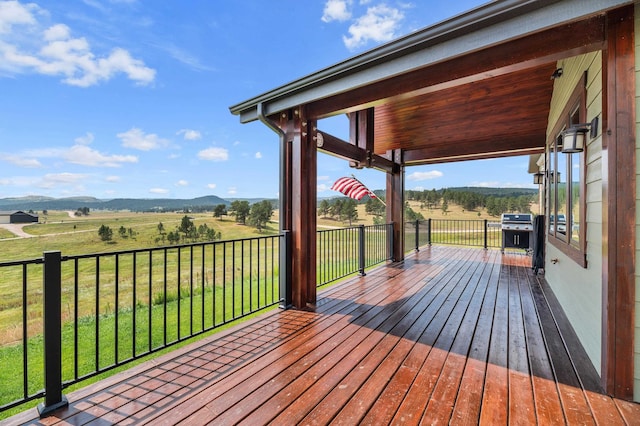 deck featuring a rural view and a lawn