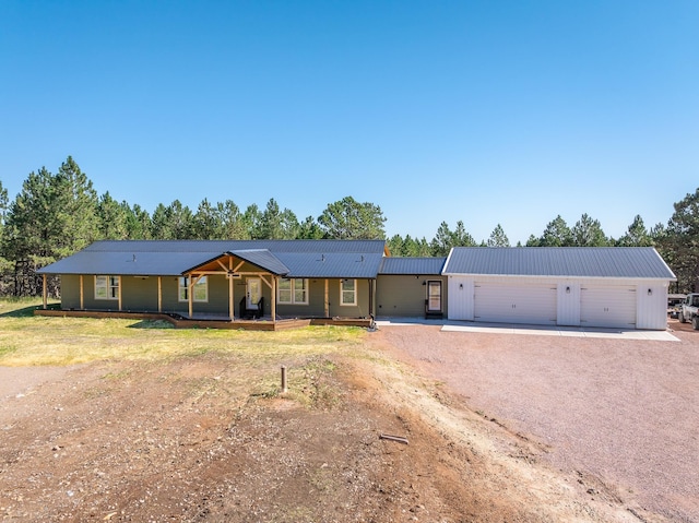 ranch-style home featuring covered porch, a front yard, and a garage