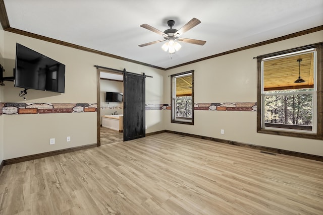 bedroom with a barn door, light hardwood / wood-style floors, ensuite bathroom, ceiling fan, and crown molding