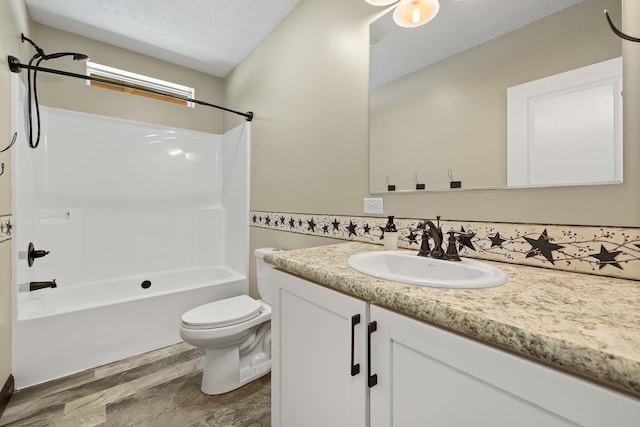 full bathroom with vanity, bathtub / shower combination, a textured ceiling, hardwood / wood-style flooring, and toilet