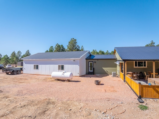 rear view of house featuring central AC unit and a patio