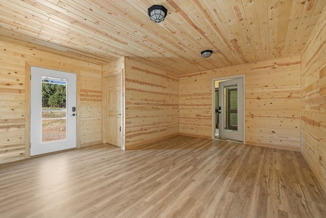 spare room featuring hardwood / wood-style flooring and wooden walls