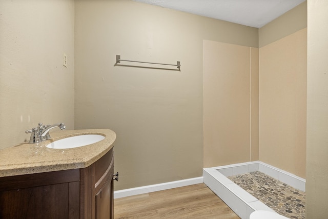 bathroom featuring walk in shower, hardwood / wood-style flooring, and vanity