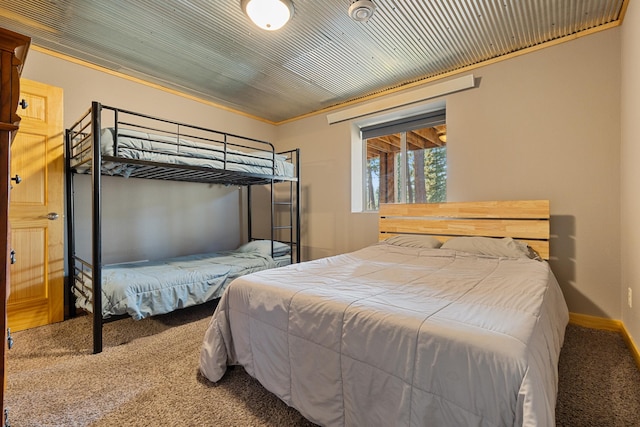 carpeted bedroom with wood ceiling, baseboards, and ornamental molding