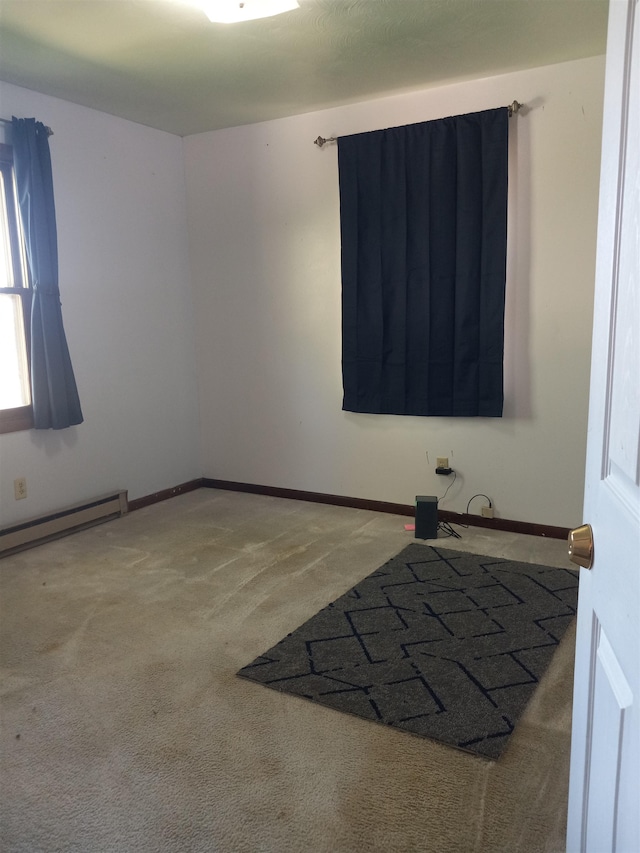 spare room featuring a baseboard radiator and carpet