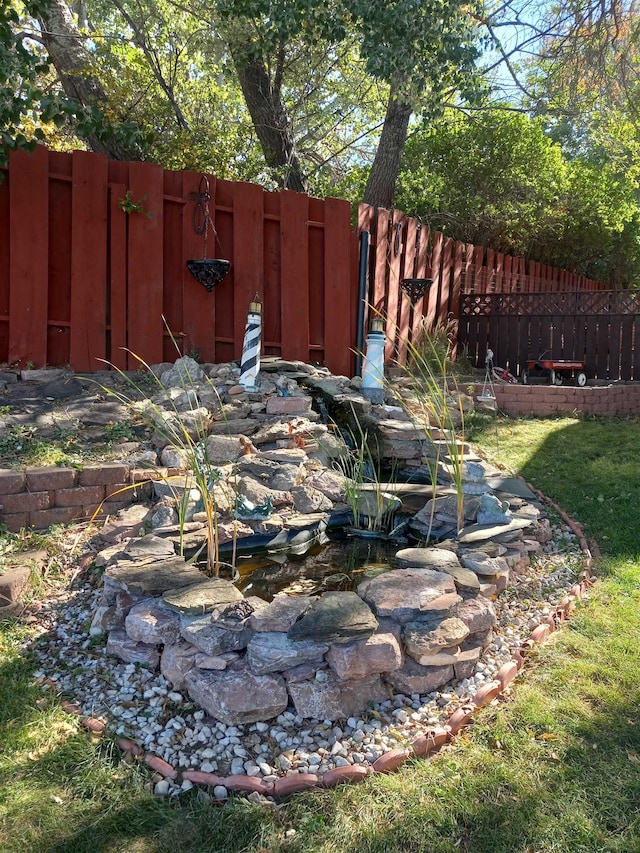 view of yard featuring a small pond