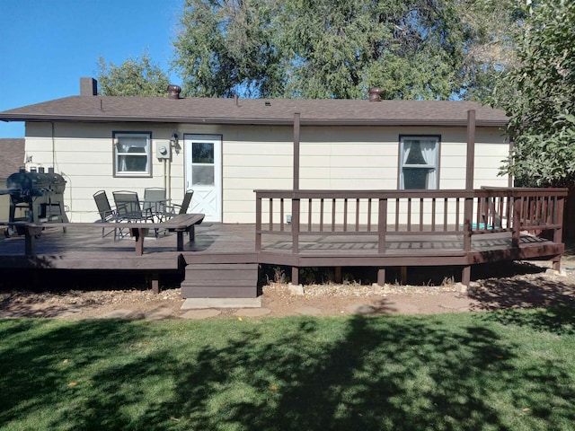 back of property with a yard and a deck