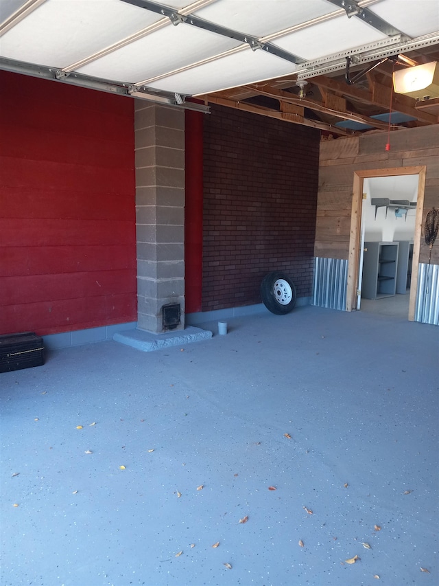 garage featuring a garage door opener and wooden walls