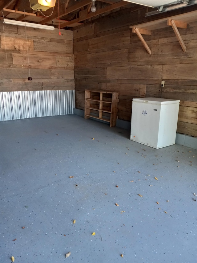 garage with white fridge and wooden walls