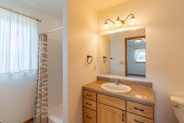 bathroom with vanity, walk in shower, and toilet