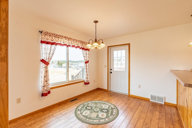 doorway featuring a notable chandelier and hardwood / wood-style flooring