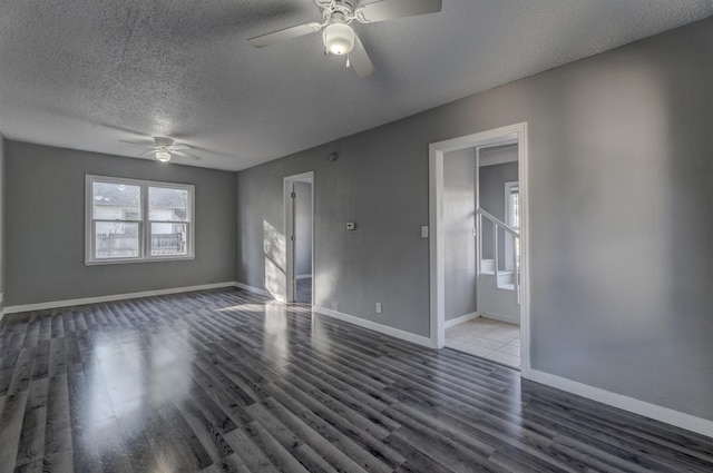 spare room with dark hardwood / wood-style floors, a textured ceiling, and ceiling fan