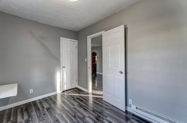 unfurnished bedroom featuring a baseboard radiator and dark wood-type flooring