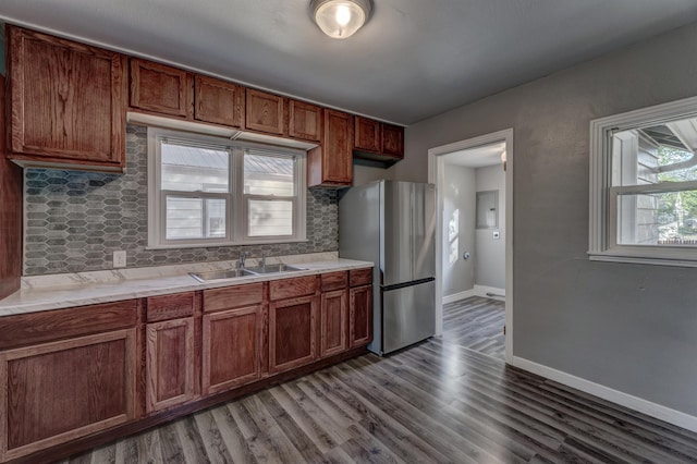 kitchen featuring decorative backsplash, wood-type flooring, stainless steel fridge, and sink