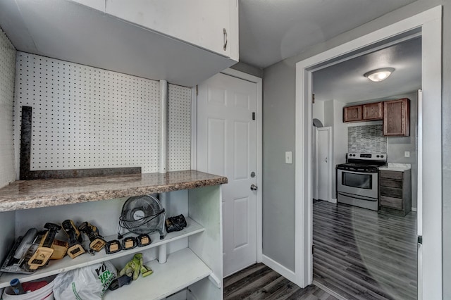 kitchen with decorative backsplash, dark hardwood / wood-style floors, and stainless steel stove