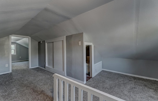 additional living space with carpet flooring and vaulted ceiling