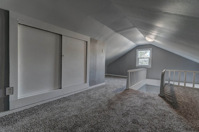 bonus room featuring a textured ceiling, vaulted ceiling, and carpet flooring