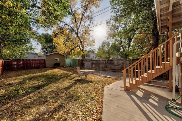 view of yard featuring a storage unit and a patio area