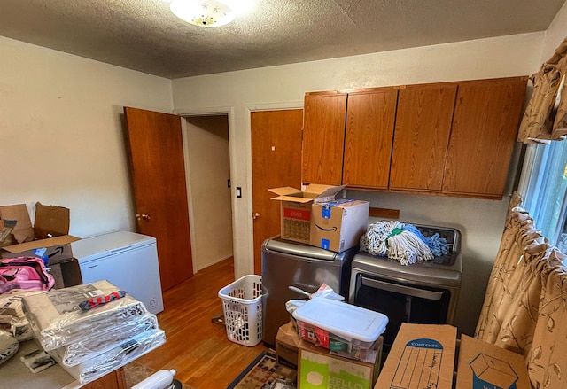 laundry area featuring hardwood / wood-style flooring, a textured ceiling, and cabinets