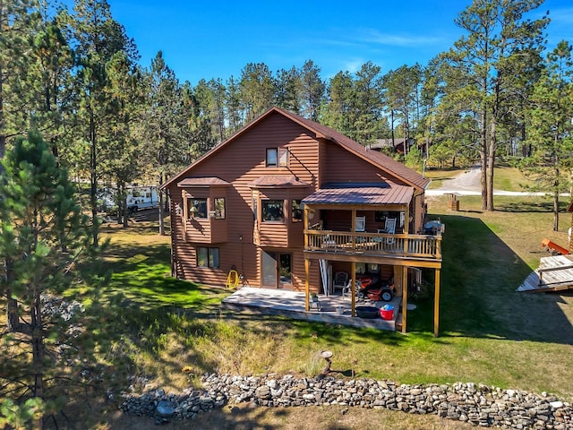 rear view of property with a patio and a lawn