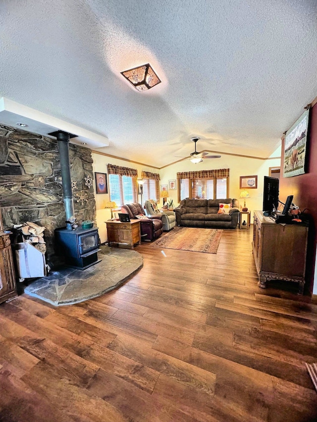 living room featuring a wood stove, a textured ceiling, lofted ceiling, and dark hardwood / wood-style flooring