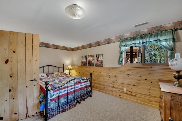 bedroom with carpet and wood walls