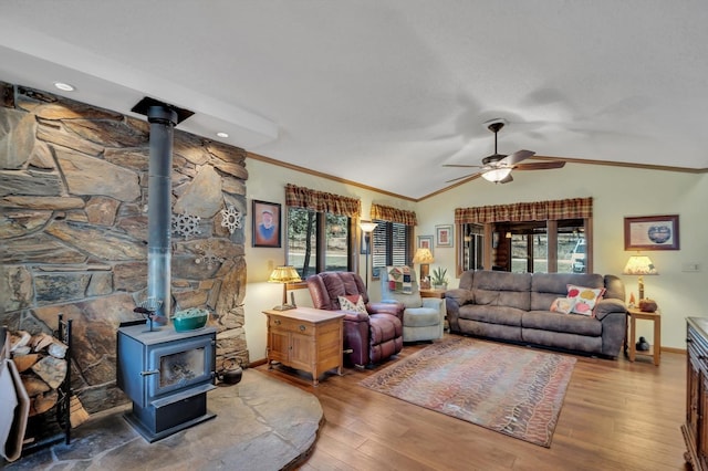 living room with a wood stove, hardwood / wood-style floors, lofted ceiling, and plenty of natural light