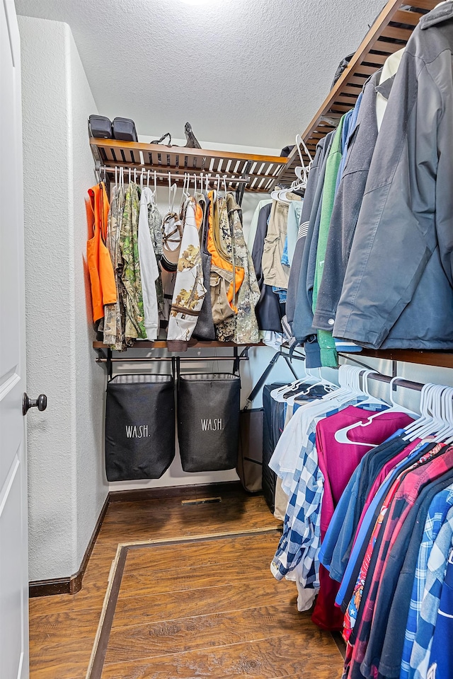 walk in closet with dark hardwood / wood-style flooring