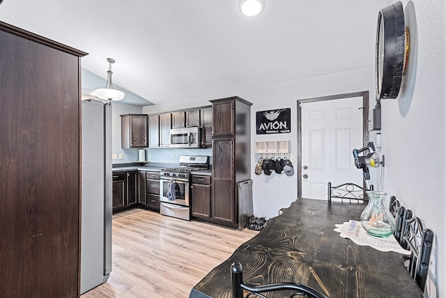 kitchen featuring appliances with stainless steel finishes, light hardwood / wood-style flooring, dark brown cabinets, and pendant lighting