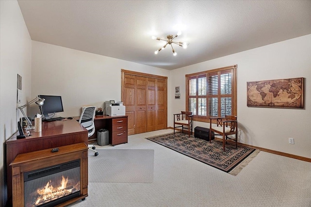 carpeted office space featuring a textured ceiling and a chandelier