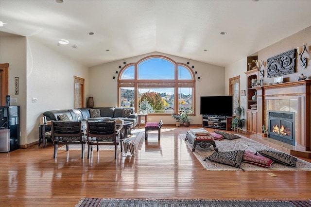 living room with lofted ceiling, light hardwood / wood-style flooring, and a fireplace