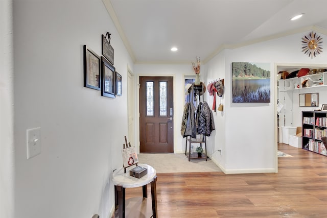 foyer entrance featuring crown molding and light wood-type flooring