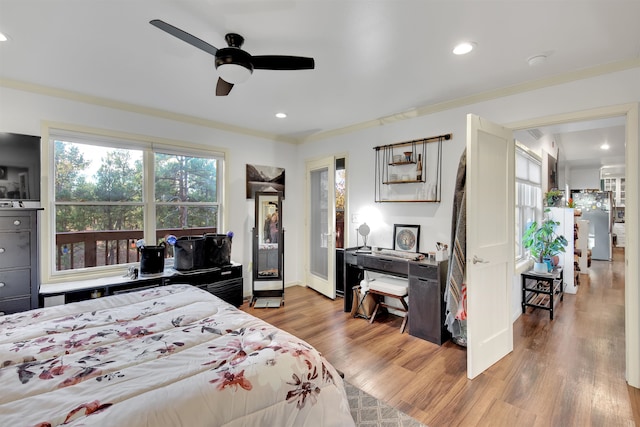 bedroom with stainless steel refrigerator, ornamental molding, hardwood / wood-style flooring, and ceiling fan