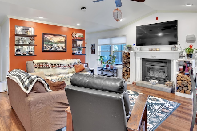 living room with lofted ceiling, crown molding, light hardwood / wood-style floors, and ceiling fan