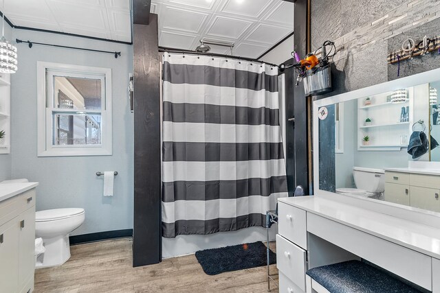 bathroom featuring vanity, toilet, a shower with curtain, and hardwood / wood-style floors