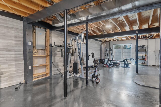 workout room with electric panel and concrete flooring