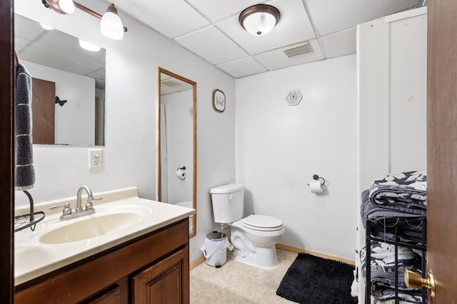 bathroom with vanity, a paneled ceiling, and toilet