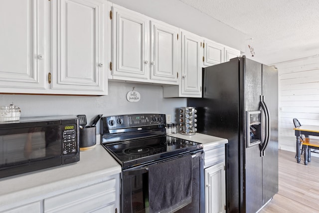 kitchen featuring white cabinetry, light hardwood / wood-style floors, black appliances, and a textured ceiling