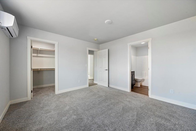 10899 Eagle Ct, Belle Fourche, SD 57717 - unfurnished bedroom with carpet, an AC wall unit, baseboards, a spacious closet, and a closet