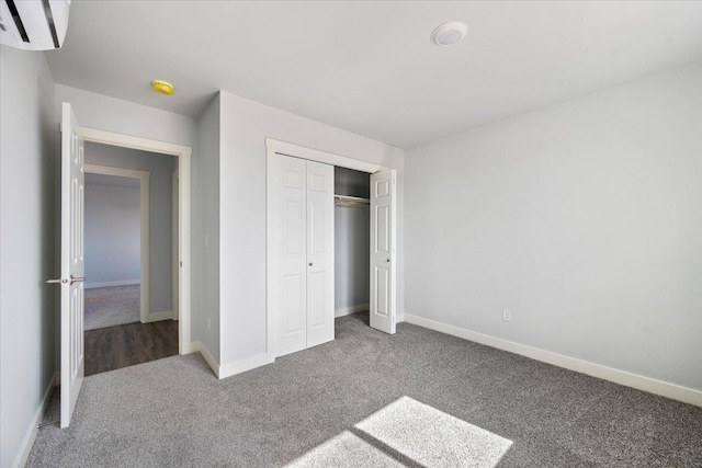 10899 Eagle Ct, Belle Fourche, SD 57717 - unfurnished bedroom featuring an AC wall unit, carpet, baseboards, and a closet