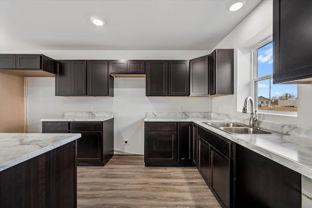 10899 Eagle Ct, Belle Fourche, SD 57717 - kitchen featuring a sink, light countertops, light wood-style floors, recessed lighting, and dark brown cabinets