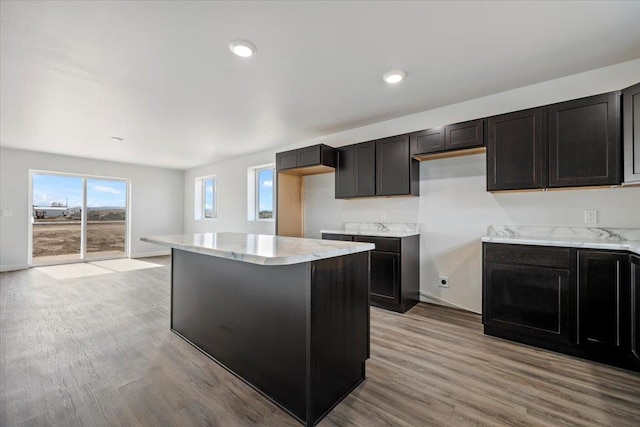 10899 Eagle Ct, Belle Fourche, SD 57717 - kitchen with light wood-style flooring, a center island, and light stone counters