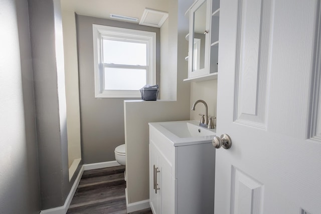 bathroom featuring vanity, wood-type flooring, and toilet