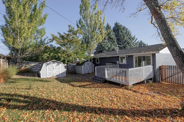 rear view of house with a storage unit, a deck, and a lawn