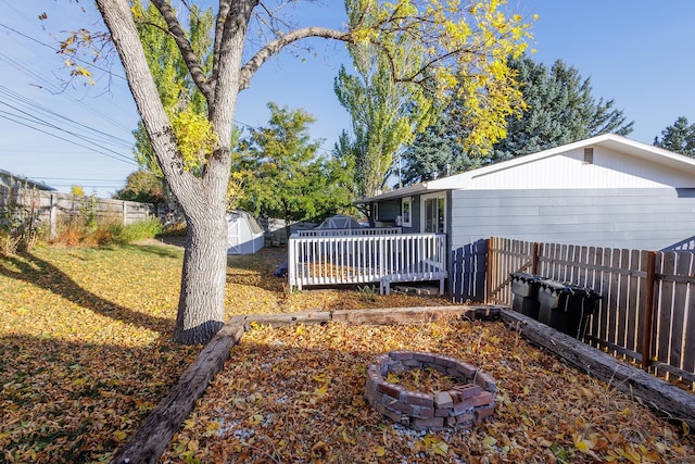 view of yard featuring an outdoor fire pit and a wooden deck